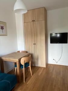 a living room with a wooden table and a cabinet at Studio 4 in Arcueil