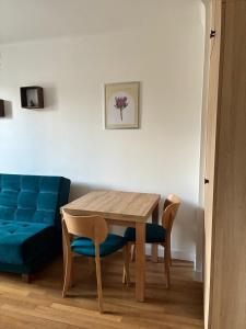 a dining room table and chairs with a blue couch at Studio 4 in Arcueil