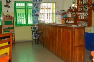 a restaurant with a wooden bar with stools at Hotel JB&G in Cotonou
