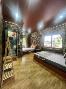 a bedroom with a bed and a stone wall at A THÁM homestay in Dam Thuy