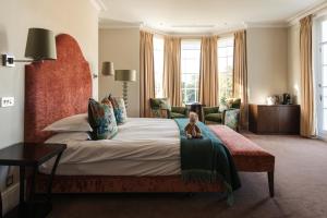 a bedroom with a bed with a teddy bear sitting on it at Bedford Lodge Hotel & Spa in Newmarket +58 photos