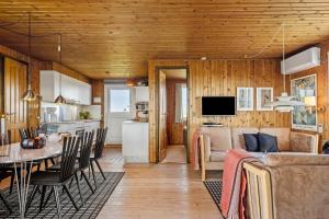 a living room and kitchen with a couch and a table at 5514-Hvide-Sande-Riskrogvej-18-C in Havrvig