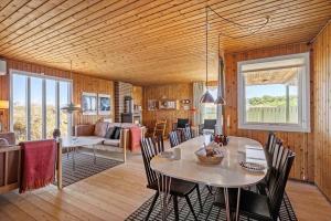 a dining room and living room with a table and chairs at 5514-Hvide-Sande-Riskrogvej-18-C in Havrvig