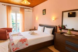 a bedroom with a bed and a chair and a mirror at Annamaria Studios & Apartments in Petra