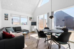 a living room with a couch and a table and chairs at 944-Hvide-Sande-Langsand-143 in Hvide Sande