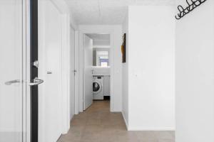 a hallway with a washer and dryer in a house at 944-Hvide-Sande-Langsand-143 in Hvide Sande