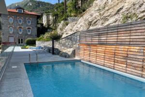 a pool of blue water in front of a building at Condominio Modern House in Menaggio