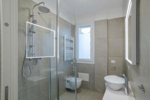 a bathroom with a shower and a toilet and a sink at Condominio Modern House in Menaggio