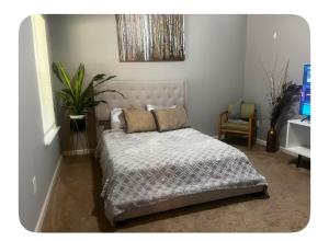 a bedroom with a bed and a plant in it at Spacious 3 bedroom 3 bathroom cozy home with patio 15 mins away from ATL in Decatur