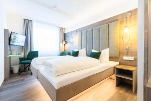 ein Hotelzimmer mit Bett und Fernseher in der Unterkunft Hotel Hennies in Isernhagen