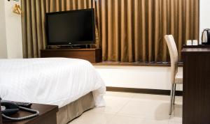 a hotel room with a bed and a flat screen tv at 安可旅店 Bravo Hotel in Taichung