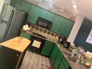 a green kitchen with a sink and a refrigerator at Spacious 3 bedroom 3 bathroom cozy home with patio 15 mins away from ATL in Decatur