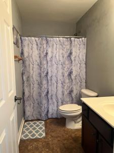 a bathroom with a toilet and a shower curtain at Spacious 3 bedroom 3 bathroom cozy home with patio 15 mins away from ATL in Decatur +11 photos