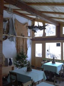 a dining room with two tables and a christmas tree at StaroplaninSki Apartments in Crni Vrh