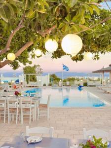 a restaurant with a pool with tables and chairs at Margarita Studios Ambelas in Ambelas