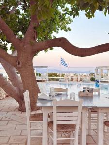 a white table and chairs sitting under a tree at Margarita Studios Ambelas in Ambelas