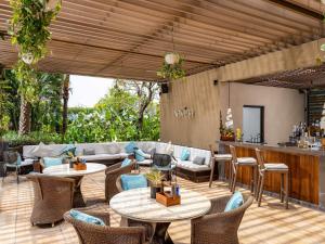 a patio with tables and chairs and a bar at Raffles Jakarta in Jakarta