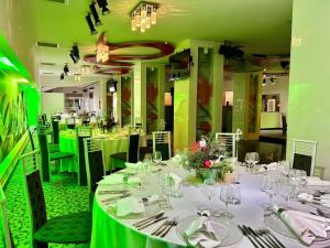 a dining room with tables and chairs with green at ibis Styles Dunarea Galati in Galaţi