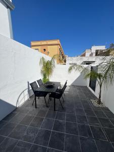 a patio with a table and chairs on a roof at Apartamentos Canoa centro y playa in Sanlúcar de Barrameda