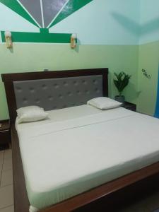 a bed with two pillows on it in a room at Hotel JB&G in Cotonou