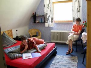 a young girl laying on a bed in a room at Frauenpension Arleta - Women only in Goslar