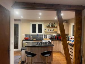 a kitchen with a counter and stools in it at Chalet for 10 with the forest in Séranon