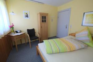 a bedroom with a bed and a desk and a desk at Frauenpension Arleta - Women only in Goslar