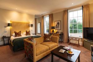 a hotel room with a bed and a couch at Bedford Lodge Hotel & Spa in Newmarket