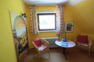 Zimmer mit einem Tisch, Stühlen und einem Fenster in der Unterkunft Frauenpension Arleta - Women only in Goslar