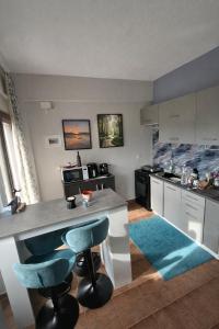 a kitchen with a counter and two blue bar stools at Angelparadise village stefani in Stefáni