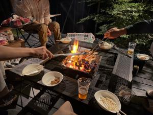 a group of people cooking food on a grill at Gubo 里山ヴィレッジ 白木 in Katsuura +62 photos