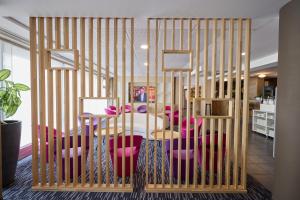 a cage with pink chairs and a table in a room at Park Hôtel & Appartements in Cholet
