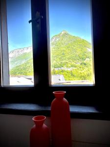 two red vases sitting in front of a window at Appartamento Lucia in Ampezzo