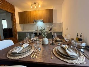 a wooden table with plates and silverware on top of it at Appartamento Lucia in Ampezzo