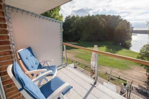 a rocking chair on a porch with a view of the water at Villa-Meehr in Bantikow