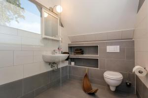 a bathroom with a sink and a toilet and a window at Villa-Meehr in Bantikow +91 photos