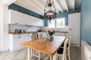 a kitchen with a wooden table and white cabinets at Binnendieck in Ahrenshoop