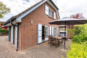 a patio with an umbrella and a table and chairs at Binnendieck in Ahrenshoop