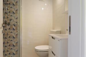 a white bathroom with a toilet and a shower at Apartment Marija in Premantura +20 photos