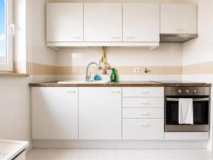a white kitchen with white cabinets and a sink at Lisbon Lux T1 Pool Gym Tennis AC - Pouso dos Anjos Apartment in Lisbon
