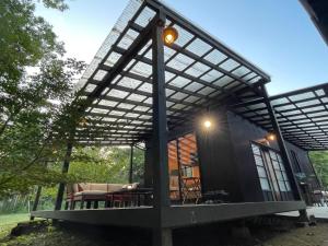 a small black house with a large roof at Gubo 里山ヴィレッジ 白木 in Katsuura