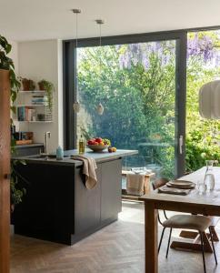 a kitchen with a large window and a table at Centrally located spacious family home in Tienen