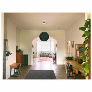 a living room with a table and a chandelier at Centrally located spacious family home in Tienen