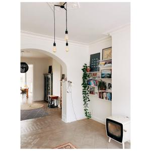 a living room with a tv and a white wall at Centrally located spacious family home in Tienen