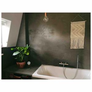 a bath tub in a bathroom with a potted plant at Centrally located spacious family home in Tienen +24 photos