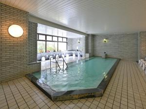 a large swimming pool in a room with at Livemax Resort Hakodate Shikabe Onsen in Shikabe