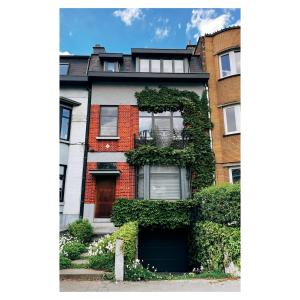 a red brick house with ivy on the side of it at Centrally located spacious family home in Tienen