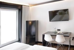 a room with a refrigerator and a table and chairs at WBE Hotel by WMM Hotels in Wittenberge