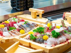 a display of sushi and other foods in wooden boxes at Livemax Resort Hakodate Shikabe Onsen in Shikabe