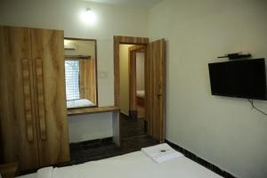 a room with a bed and a tv and a mirror at Shiv Resort & Palace in Shivpurī